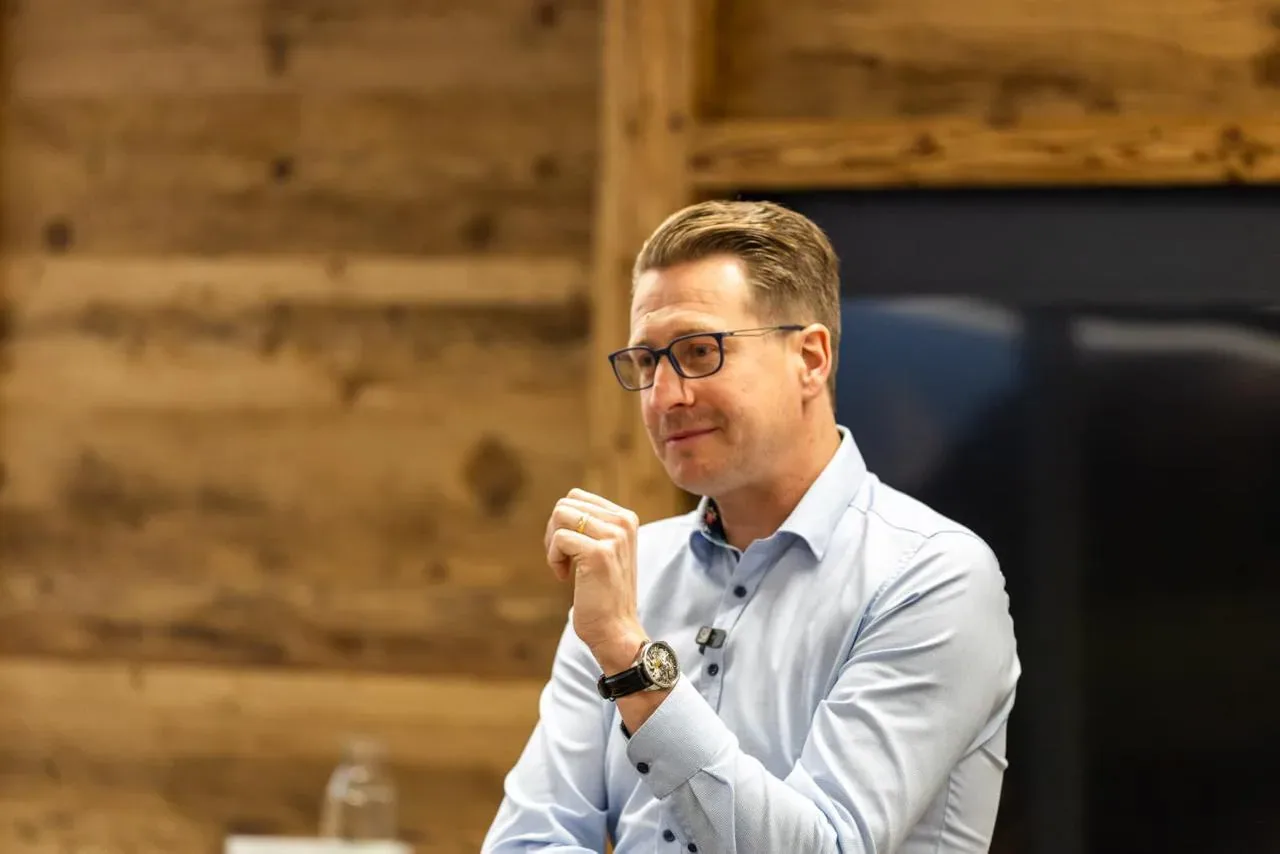 Christian Riebel im Gespräch vor einer Holzwand